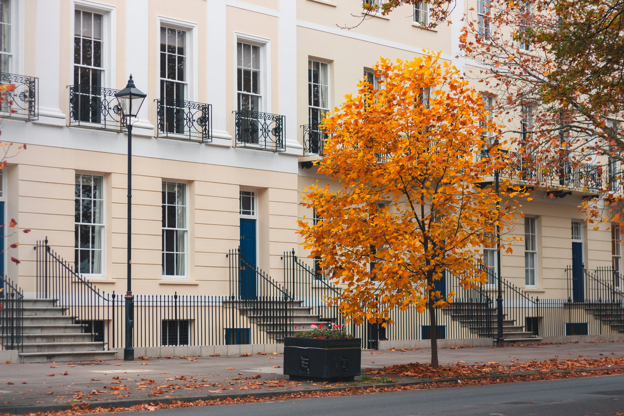 Elegant cream-fronted London townhouse with autumn leaves — ideal setting for a prime property autumn sale.